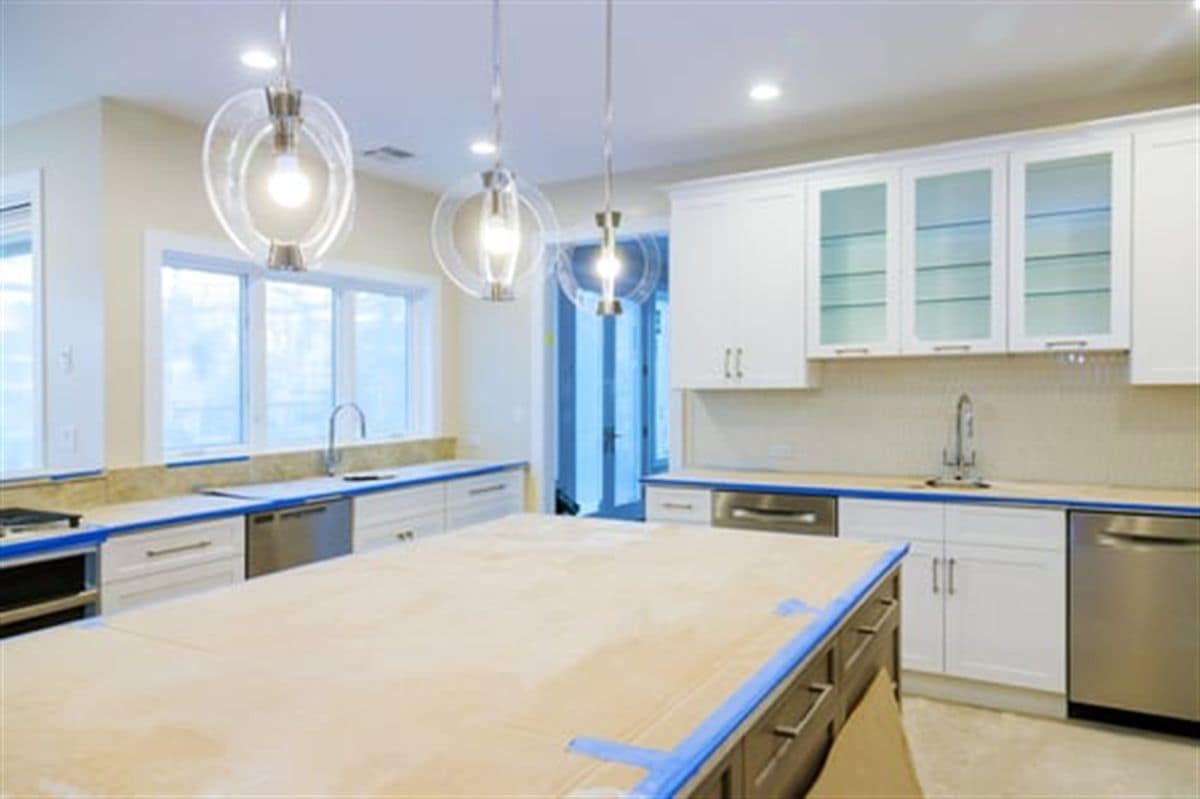 Completed kitchen renovation with a large island and custom cabinetry by Concecret Construction Corp